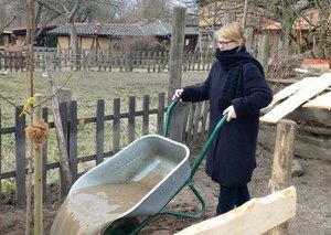 Cordelia Koch schüttet Wasser aus einer Schubkarre am Kinderbauernhof Pinke Panke